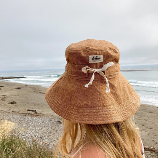 Wide brim rust colored homespun linen/cotton hand made sun hat for women. Sun hat has an adjustable tie made of cotton twill around crown of hat to adjust fit of hat. Brim can flip up or stay down with ease.