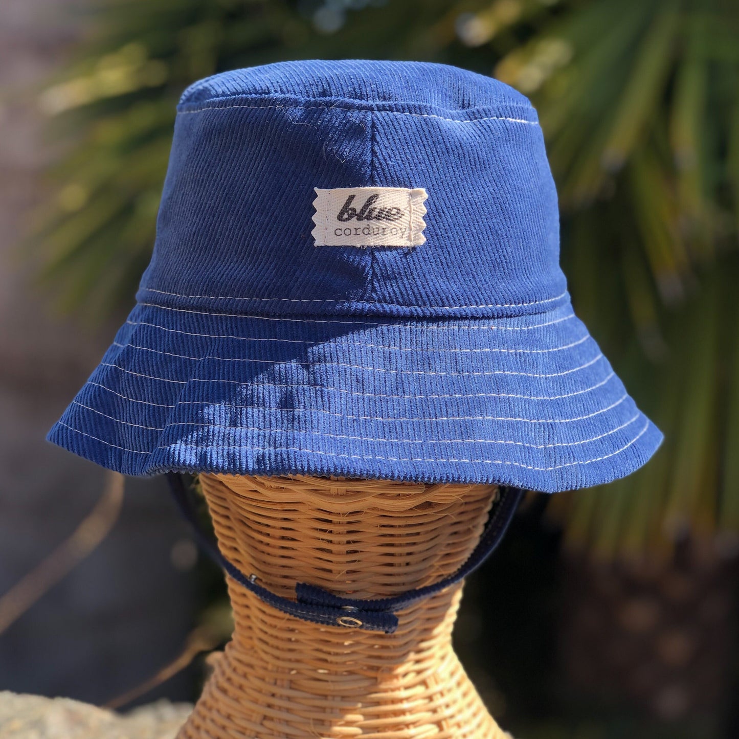 Blue Corduroy Bucket Hat for Babies on rattan mannequin head.
