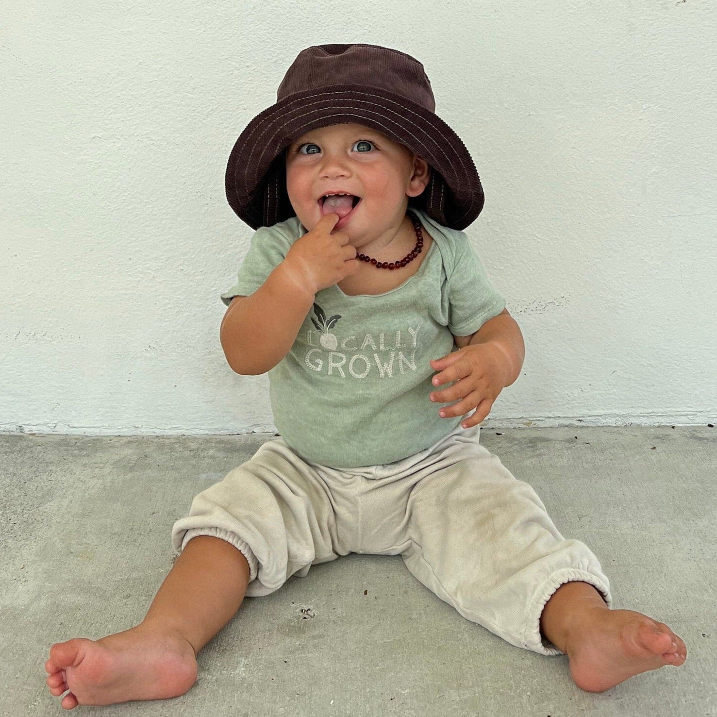 Brown corduroy bucket hat on baby.